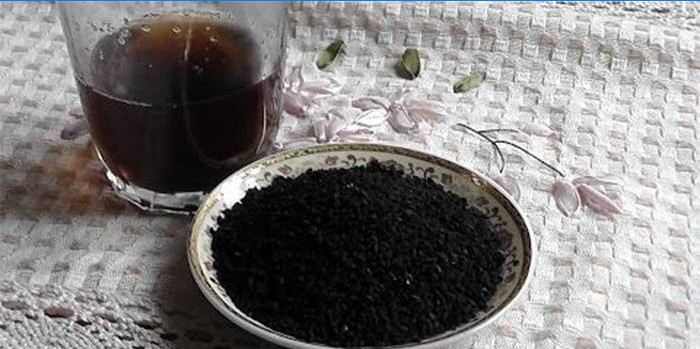İnfüzyonlu bir bardak ve siyah kimyon tohumu ile bir tabak