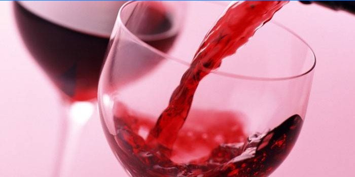 Kırmızı şarap bir bardak içine dökülür