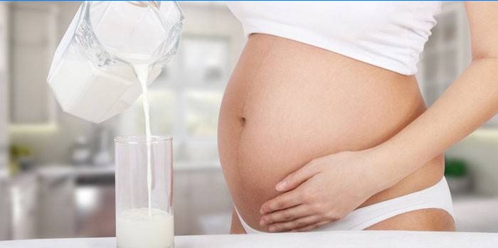 Hamile kadın fermente pişmiş süt bir bardak dökülen.